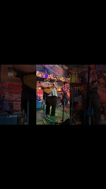 Man drinks beer while playing guitar