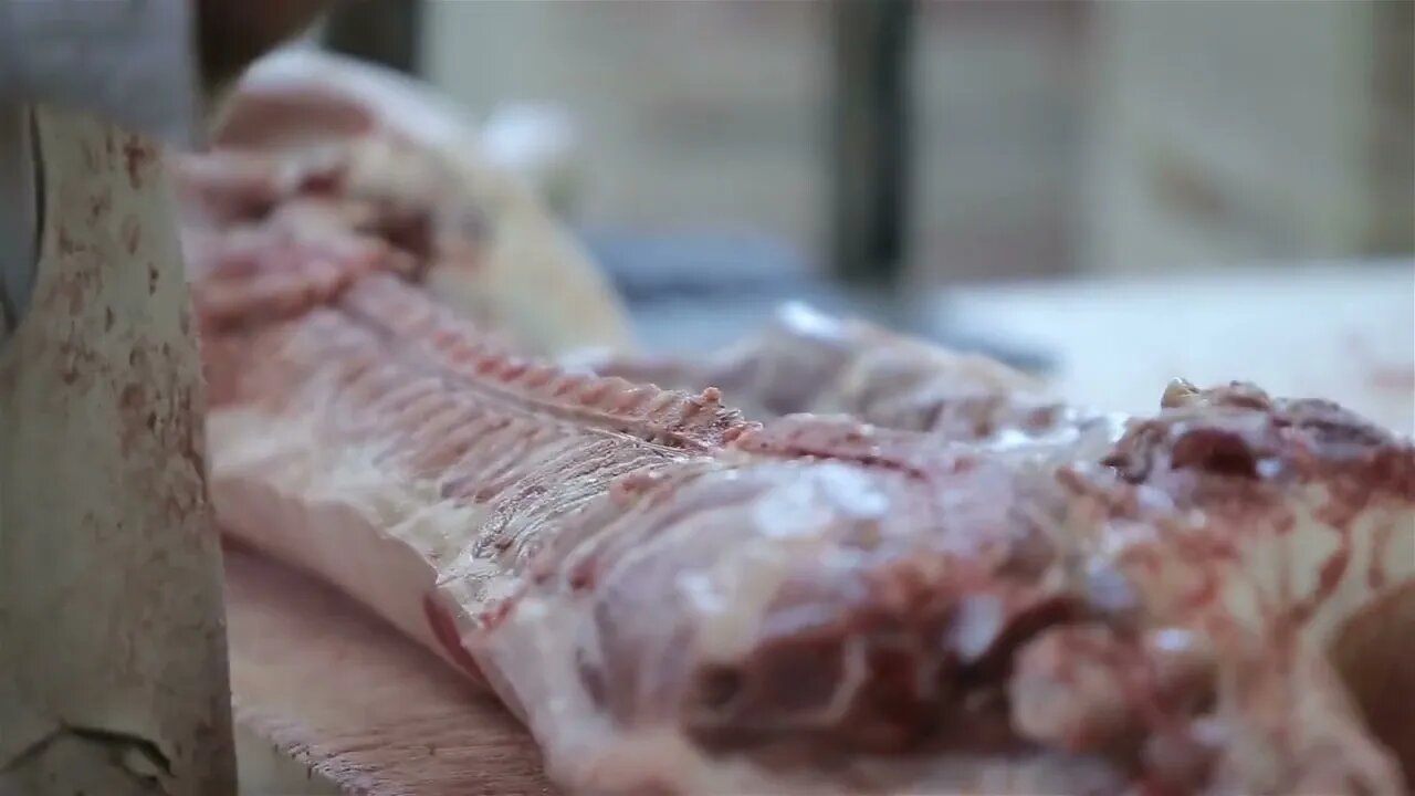 Butcher Cutting Pork Meat in Meat Factory. Fresh raw pork chops in meat factory. Meat processing in