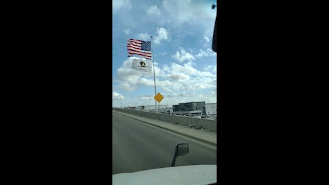 Giant John Deere flag on a windy day in Dallas Texas