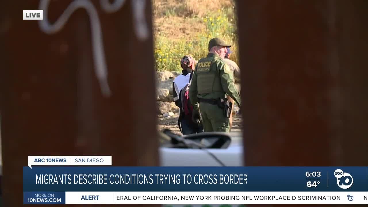 Large group of migrants including children lined up for processing at border