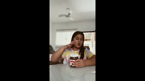 Funny girl eating Nutella with her mom