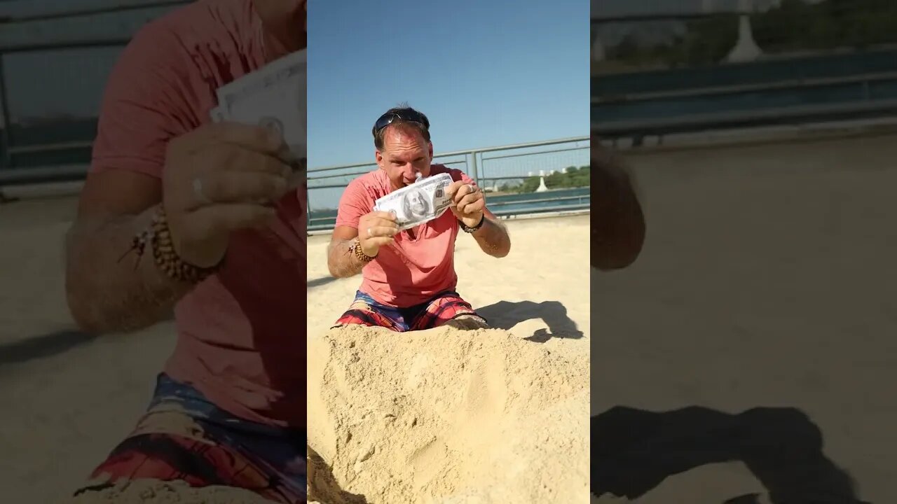 A Man Digging Money From The Sand
