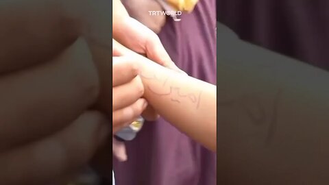 أطفال غزة يكتبون أسمائهم على ايديهم ليتعرفوا عليهم في حالة استشهادهم