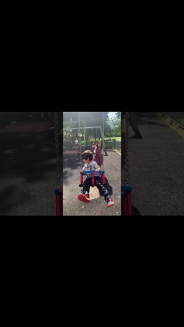 Baby girl is swing her baby brother-loads of happiness in the park