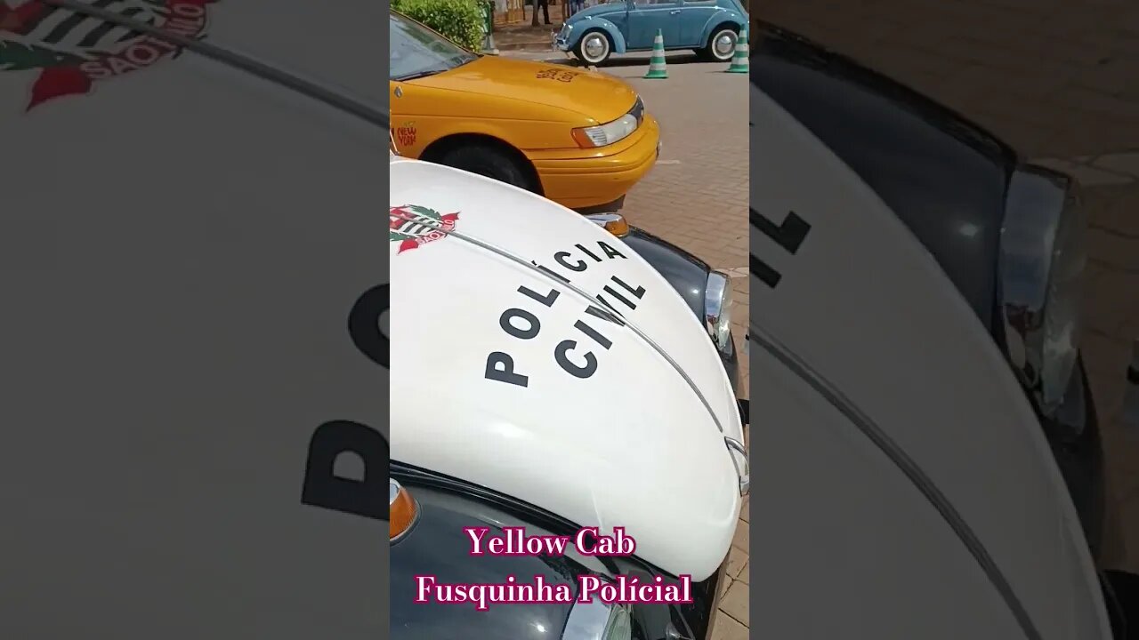 Táxi amarelo e um Fusca policial.