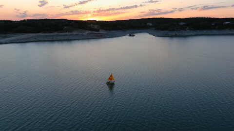 Drone Video of a Sailboat Sailing at Sunset on Medina Lake in Texas