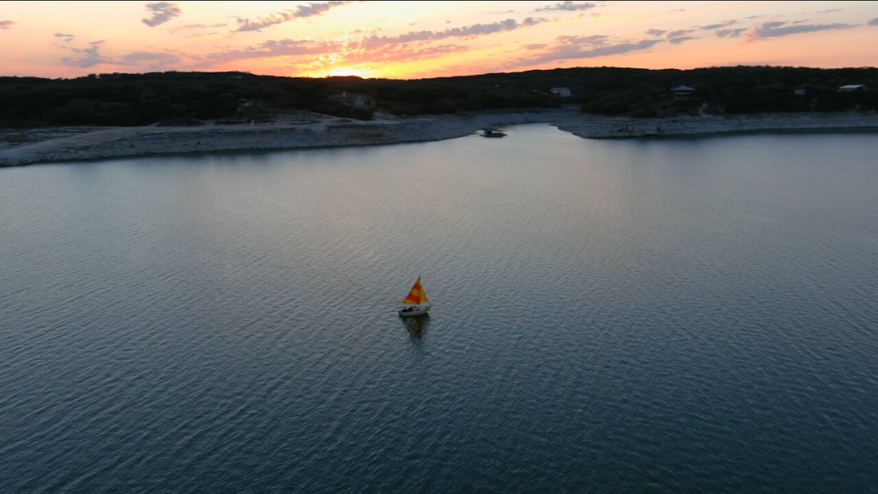 Drone Video of a Sailboat Sailing at Sunset on Medina Lake in Texas