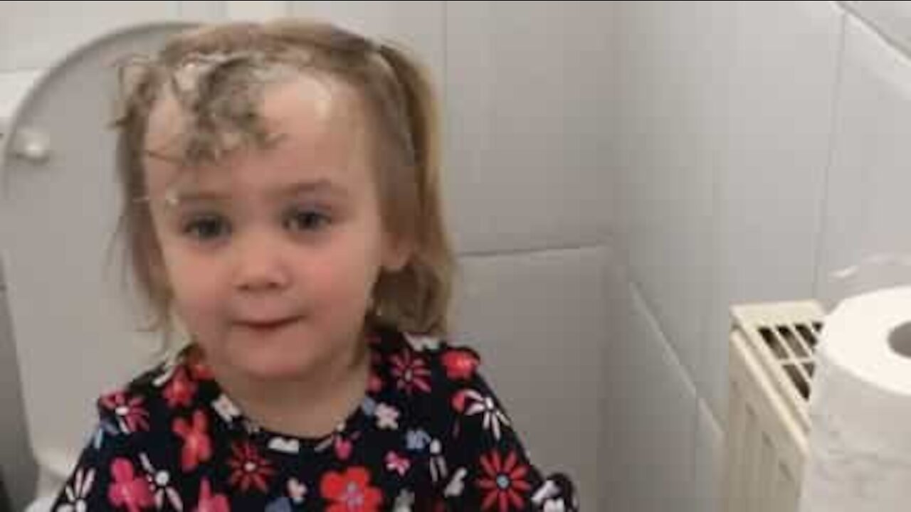 Une fillette surprise se lavant les cheveux au papier toilette