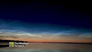 Noctilucent clouds glide across the night sky