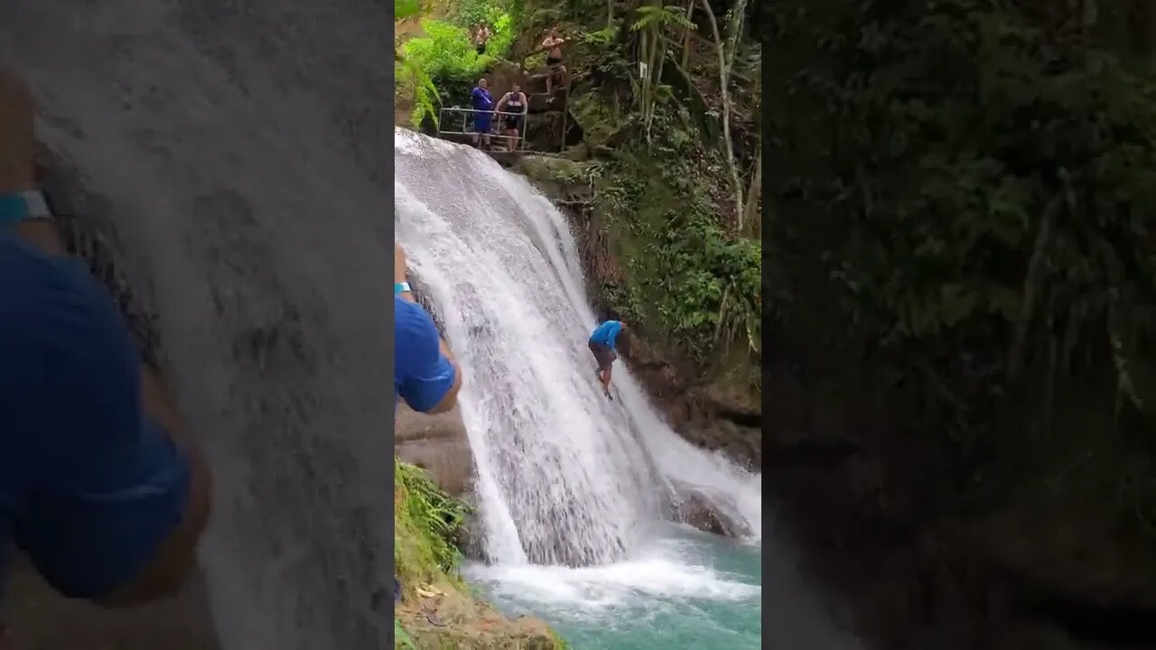 Guy walks down a waterfall at the Blue Hole in Jamaica