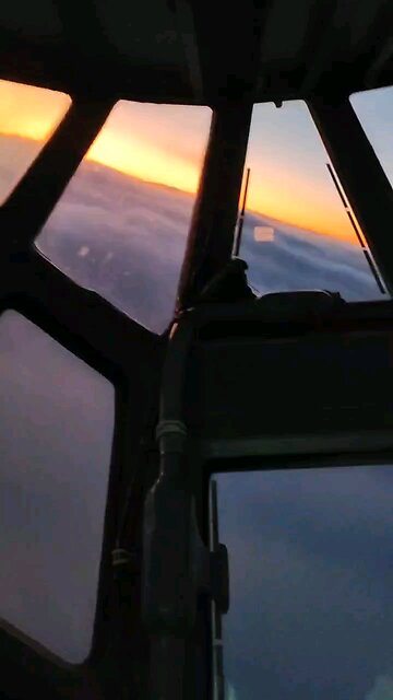 An Ilyushin Il-76 transport plane skims over a cloud bank