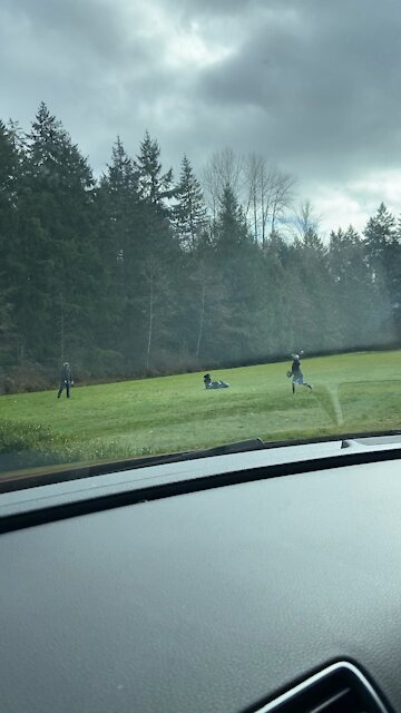Masked father and son in empty field playing catch..