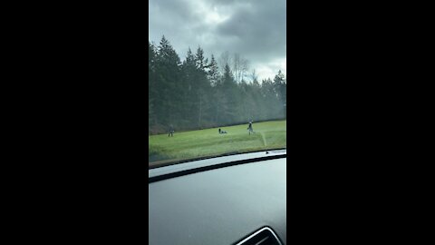 Masked father and son in empty field playing catch..