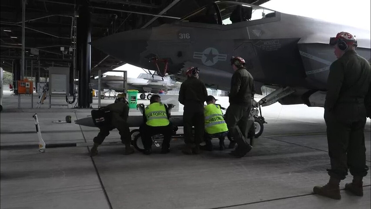 U.S Marines and Australian Airmen load CATM-120 Missiles together