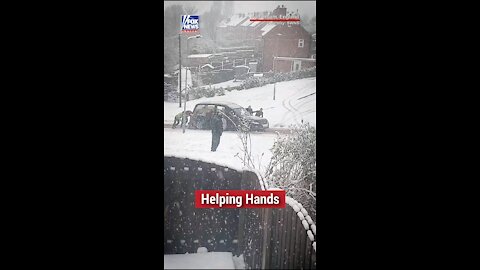 A group of strangers in England came together to help move a hearse after it got stuck in the snow.