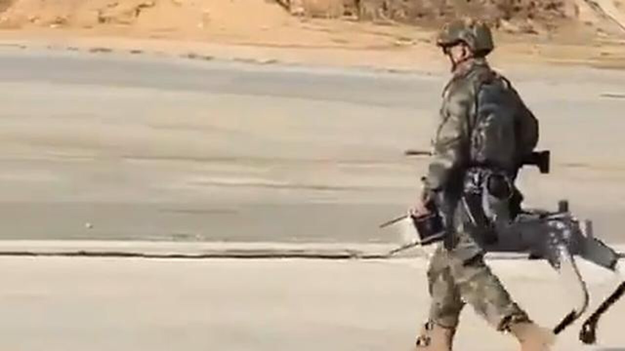 A soldier out walking his dog...but it is not just any dog - Rin Tin Robot with a machine gun