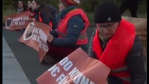 Socialist climate activist throwing plastic into gully cover.