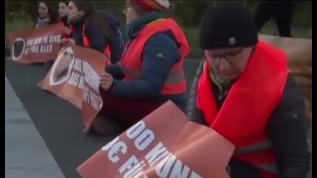Socialist climate activist throwing plastic into gully cover.