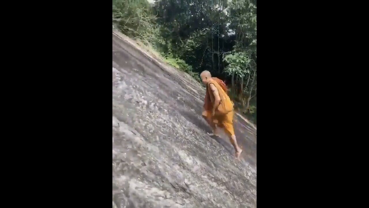 A MONK climbing with BARE FEET on the cliff that tourists climb on with the help of a rope