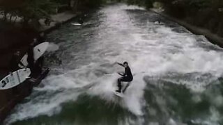 Jovem pratica surf num rio em Munique