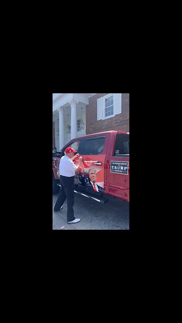 President Donald Trump signs a supporter's truck.