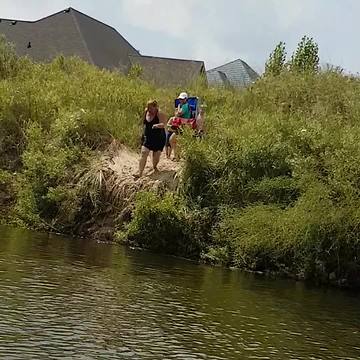 A Woman Tries To Jump Off Dirt Cliff Into Water
