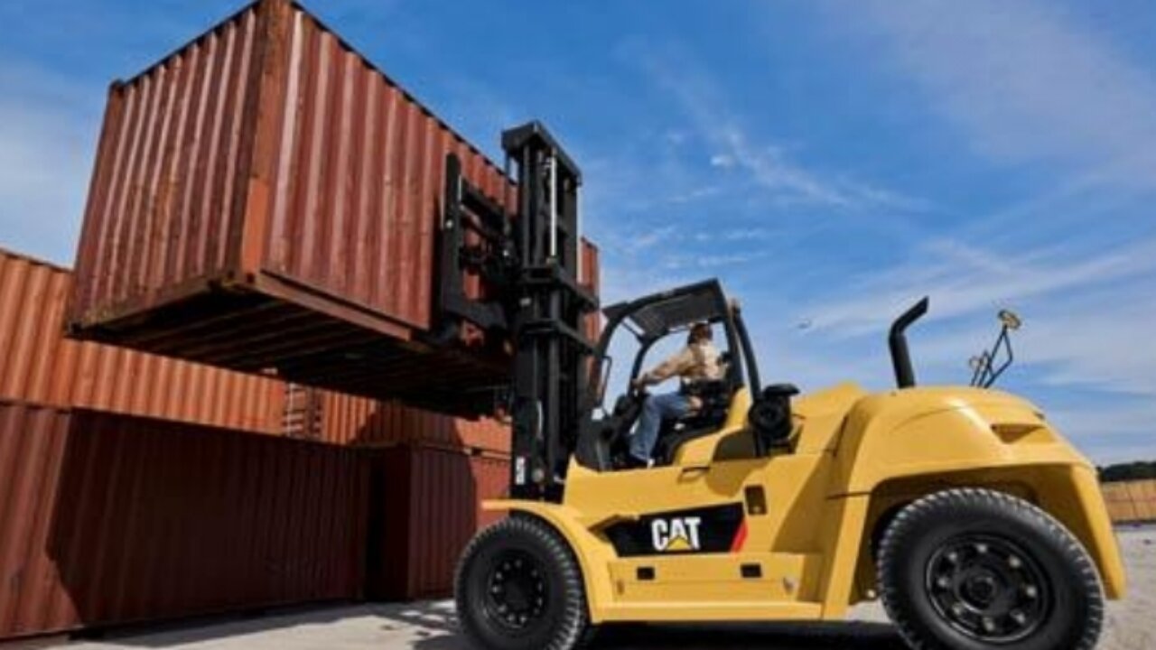 Small Forklift unloading big container from trailer.