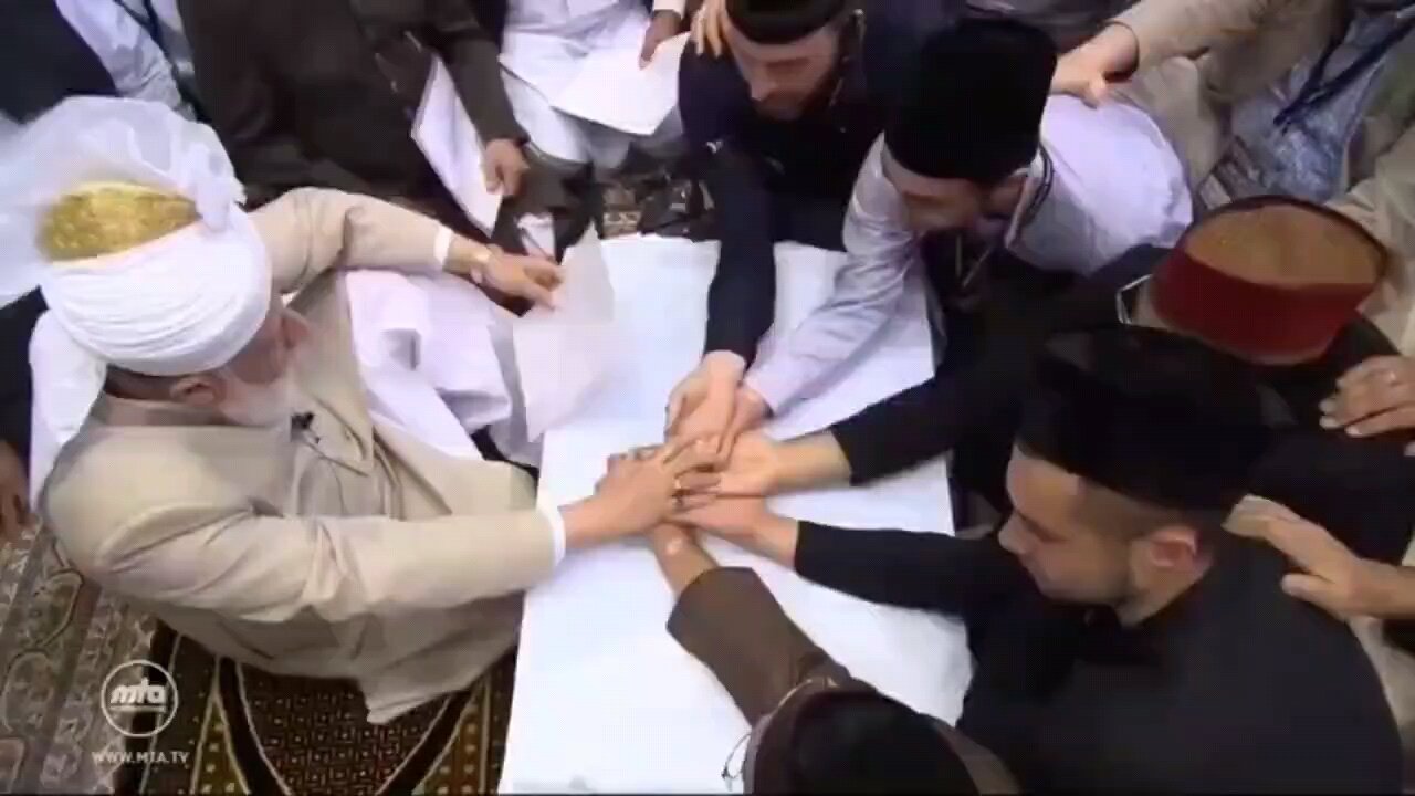 Ahmadi Muslims pledge at the hand of their Khalifa