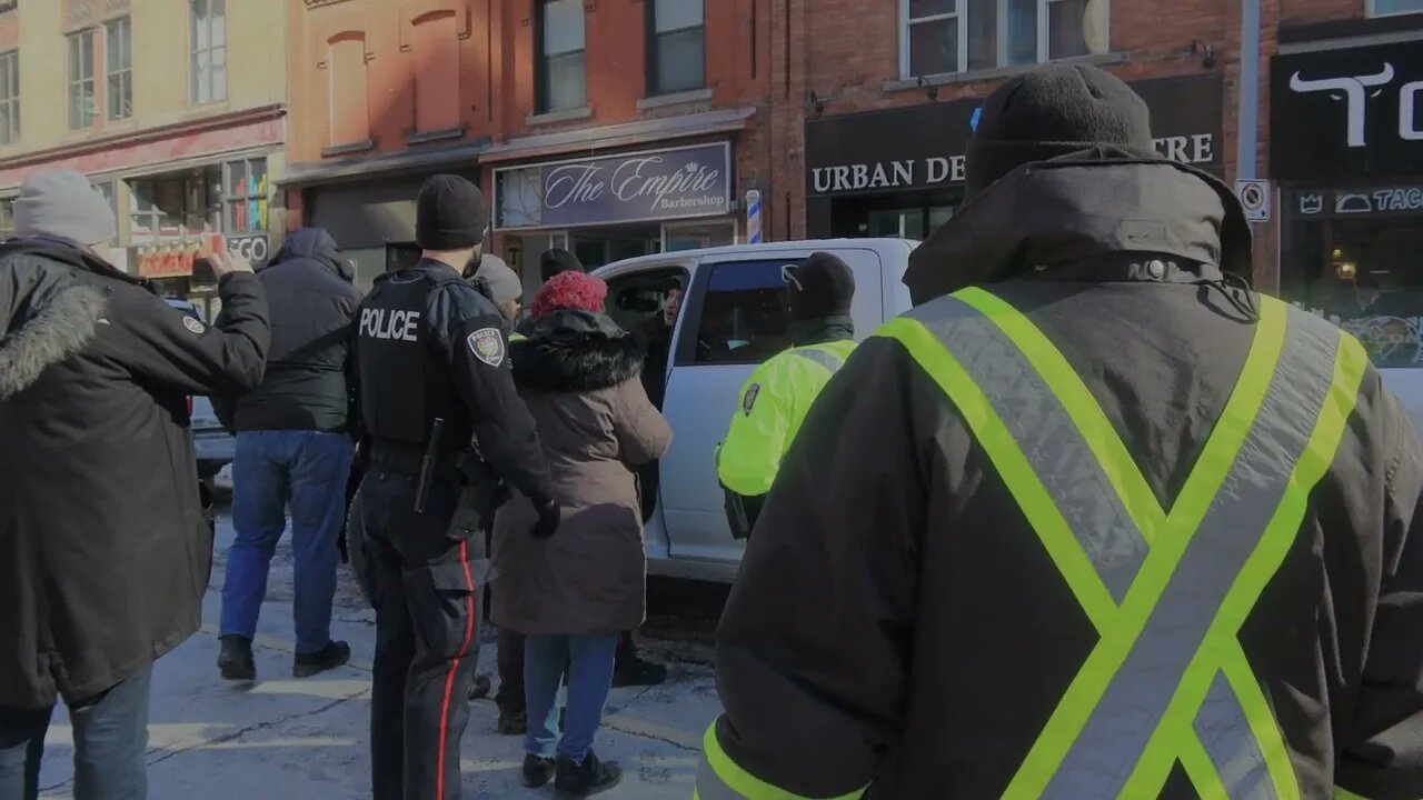 Police try to tow a legal protestor in Ottawa, Canada