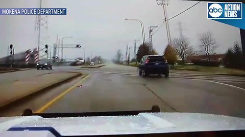 Dash cam shows police officer swerve off the road to avoid being hit by speeding train