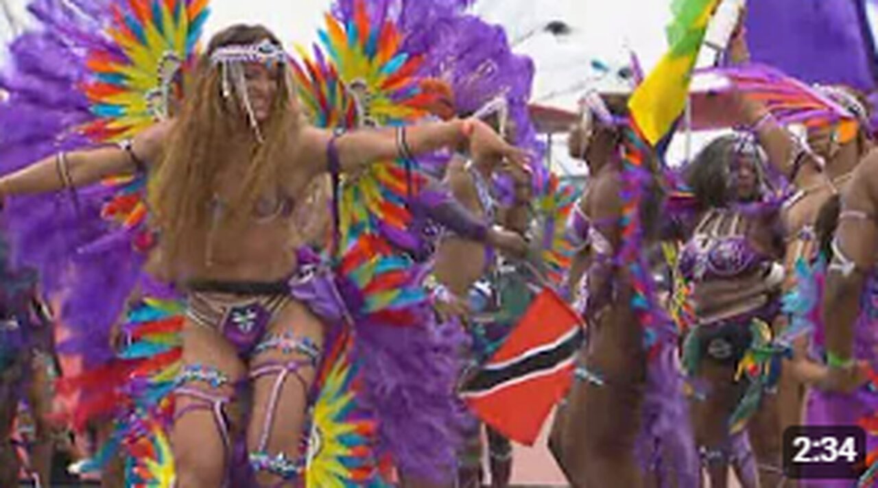 Revellers jump and wave at the 2024 Toronto Caribbean Carnival