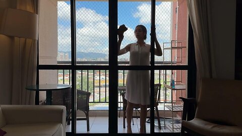 CLEANING THE WINDOW IN A WHITE TRANSPARENT DRESS