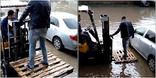 La strada è allagata e allora si fa aiutare da un muletto