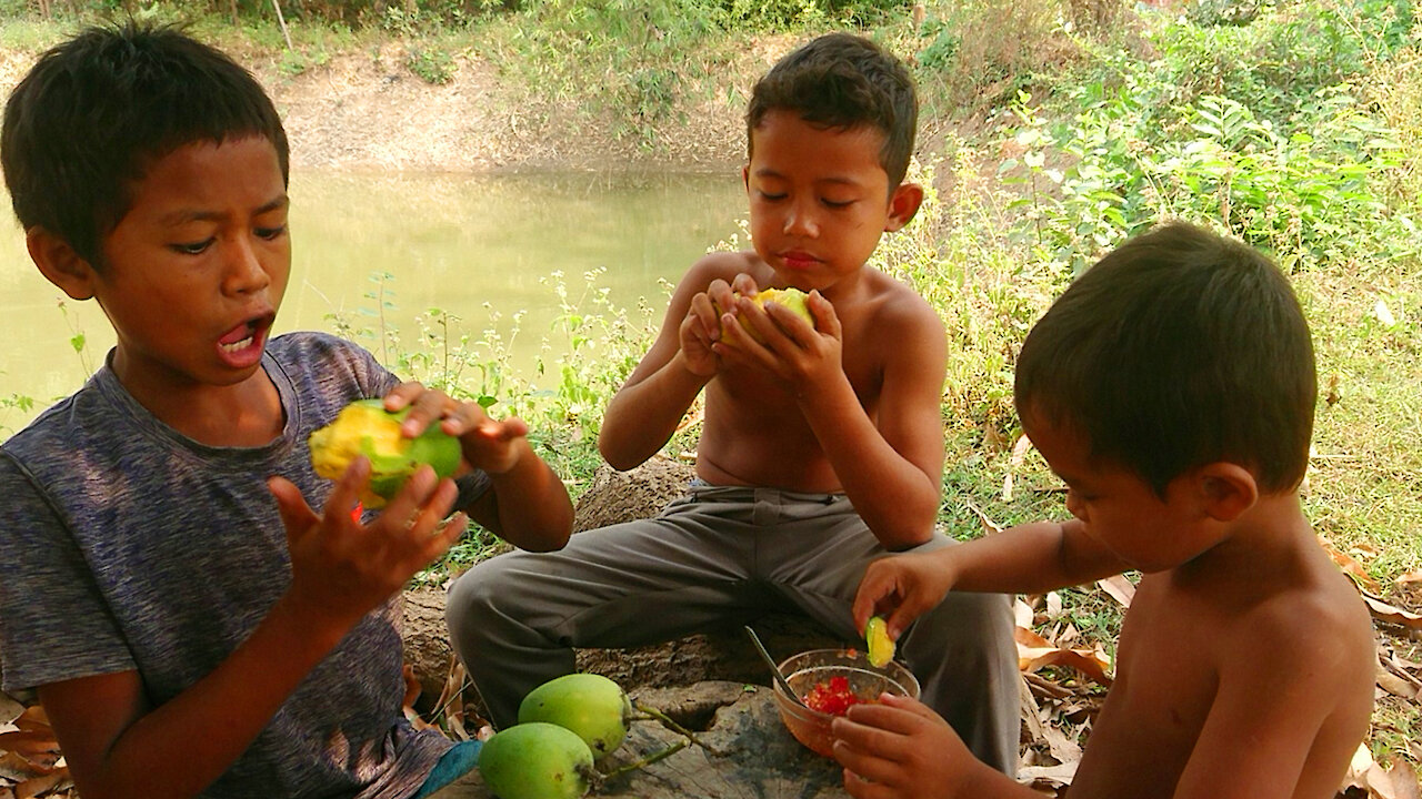 Eating green mangoes with salt peppers delicious with Young Boys