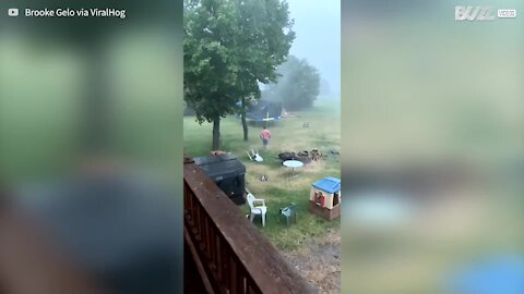 Homem enfrenta tempestade de verão para salvar trampolim