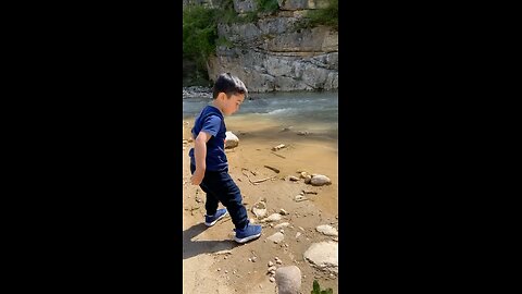 Liam is throwing stones in the river