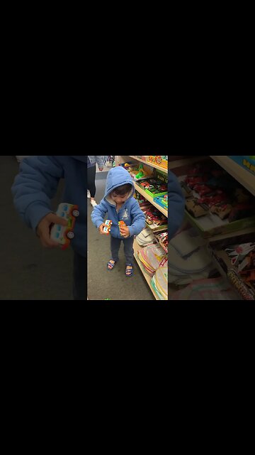 Baby boy happily plays with toys in the shop
