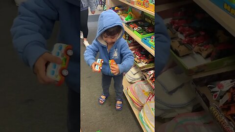 Baby boy happily plays with toys in the shop