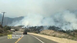 Smoke from BC wildfire climbs high over the hills and highway