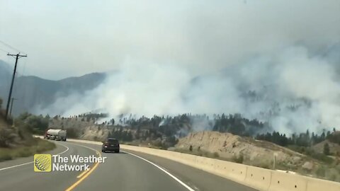 Smoke from BC wildfire climbs high over the hills and highway