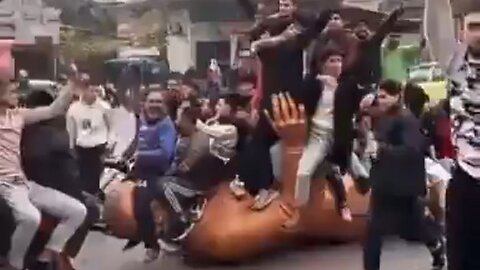 Syrians Sit On Toppled Statue Of Hafez al-Assad, Father Of Bashar al-Assad, After Regime Was Toppled