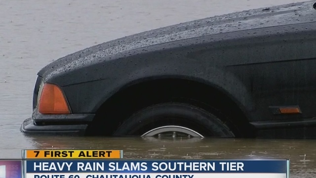 Flooded creek spills into auto shop parking lot