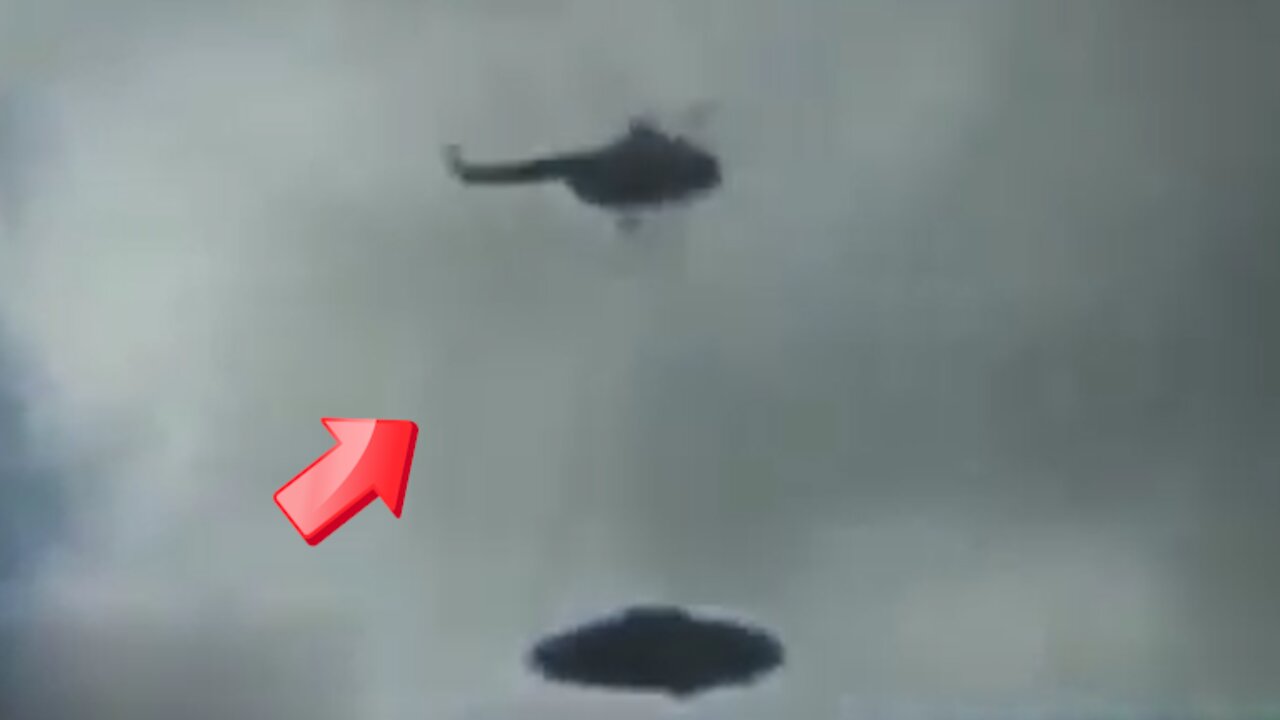 A helicopter carrying a saucer-shaped UFO in the sky above [Space]