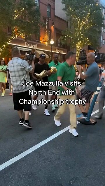 HEAD COACH OF THE CELTICS IN LIL ITALY IN BOSTON SHOWING OFF THE TROPHY