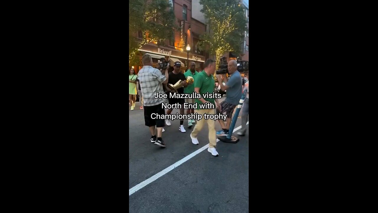 HEAD COACH OF THE CELTICS IN LIL ITALY IN BOSTON SHOWING OFF THE TROPHY