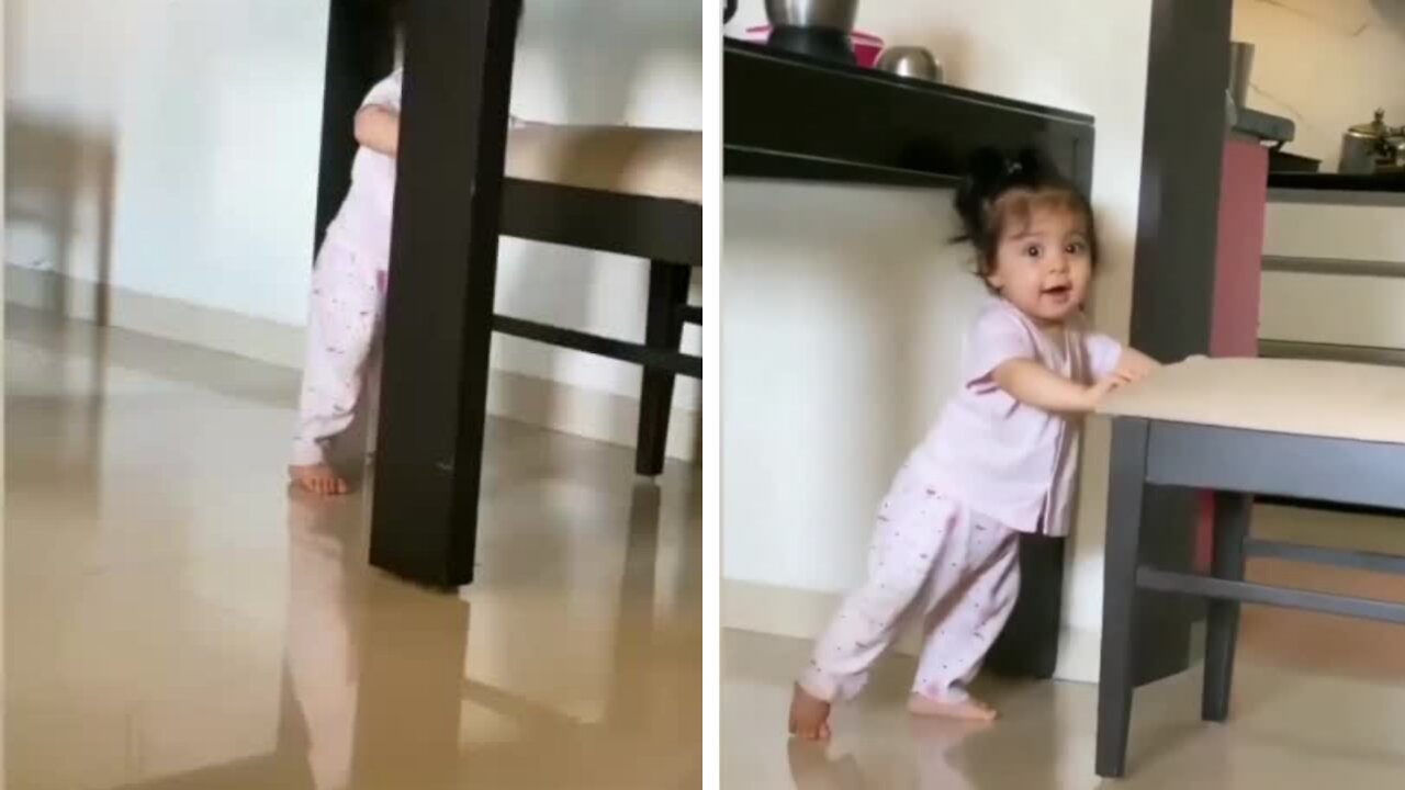 Adorable girl showing her strength by pushing the chair so far