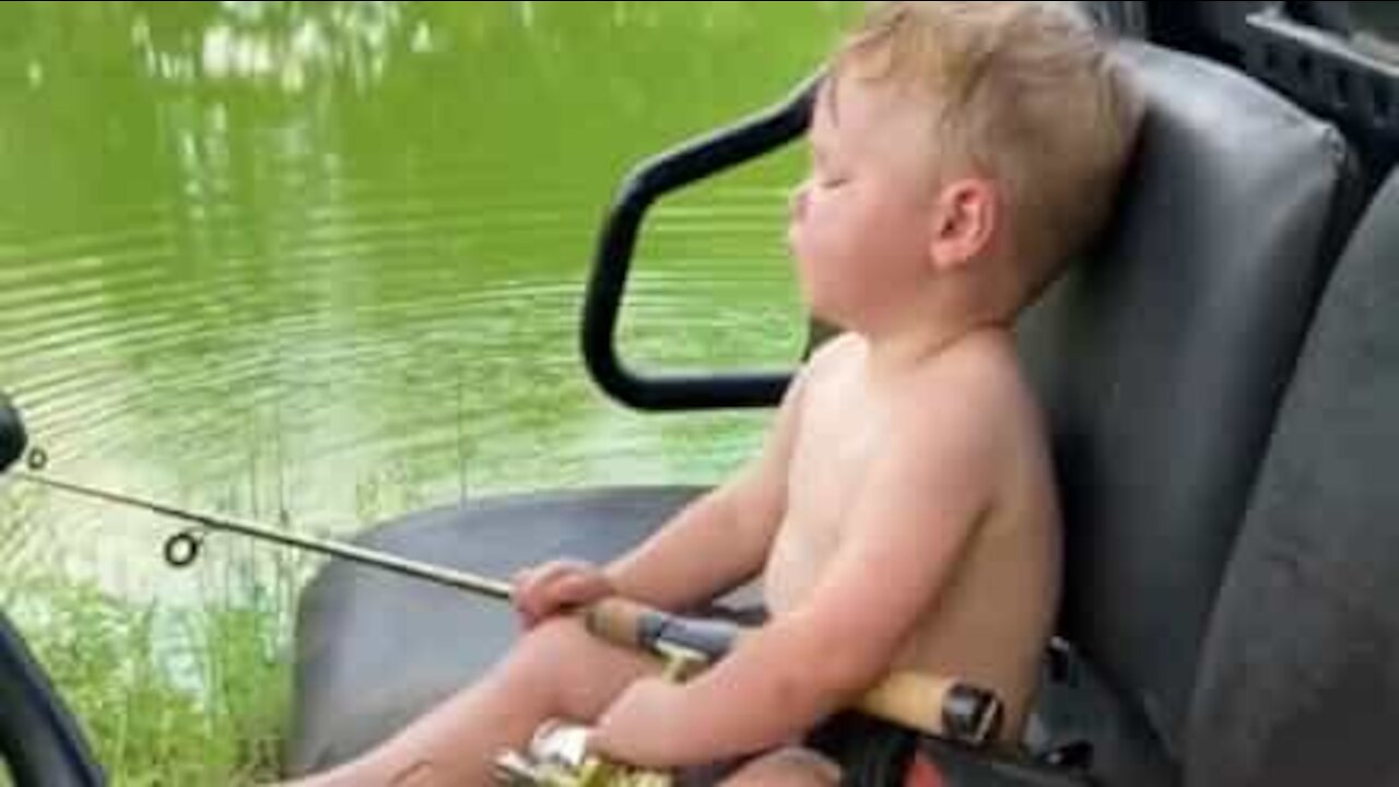 Ce petit garçon s'endort pendant qu'il pêche