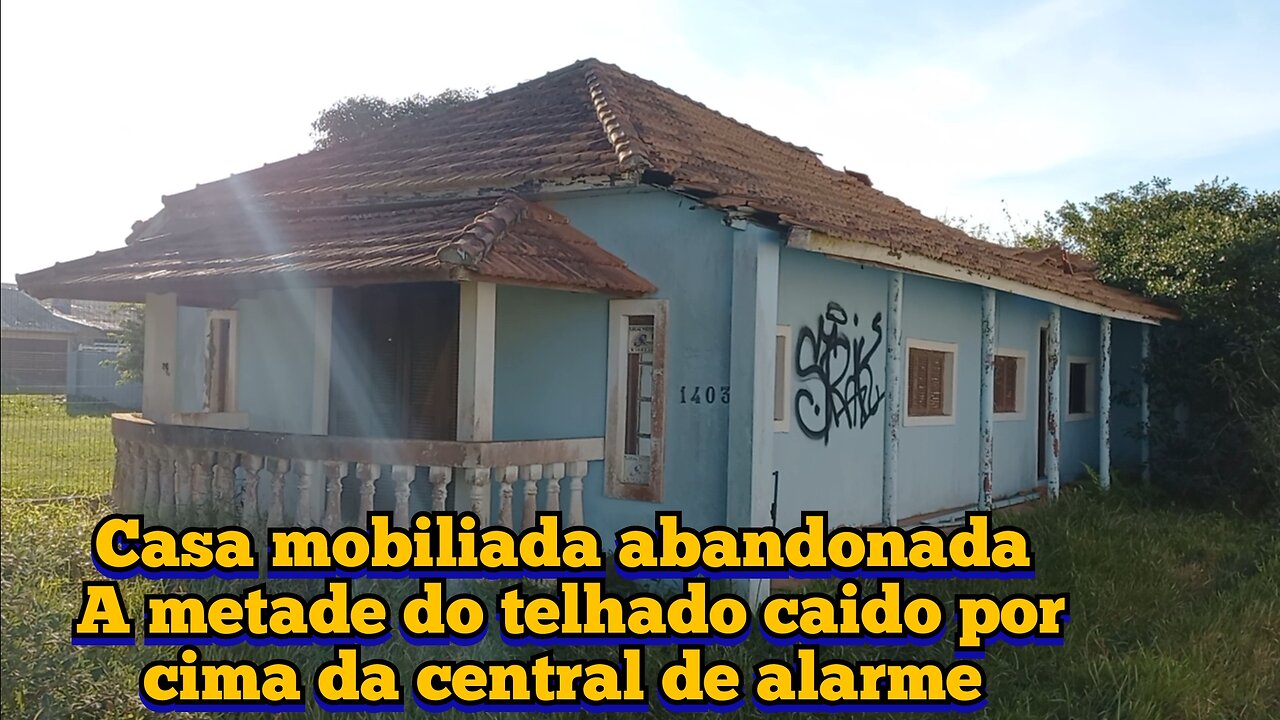 casa mobiliada abandonada com a metade do telhado desmoronado por cima da central de alarme na chuva