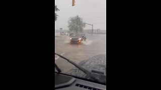 Cars drive through flooded waters