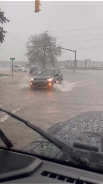 Cars drive through flooded waters
